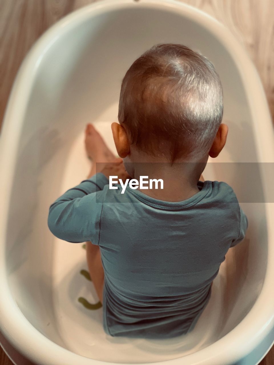 Boy sitting in bathtub at home