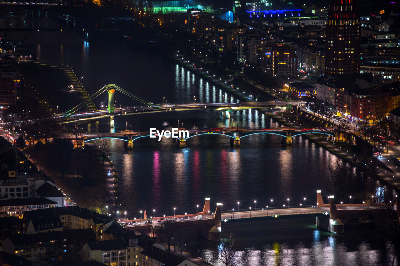 Illuminated bridge over river at night