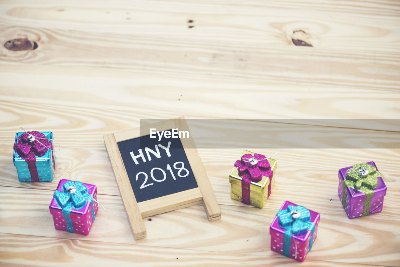 High angle view of message on blackboard by gifts over table