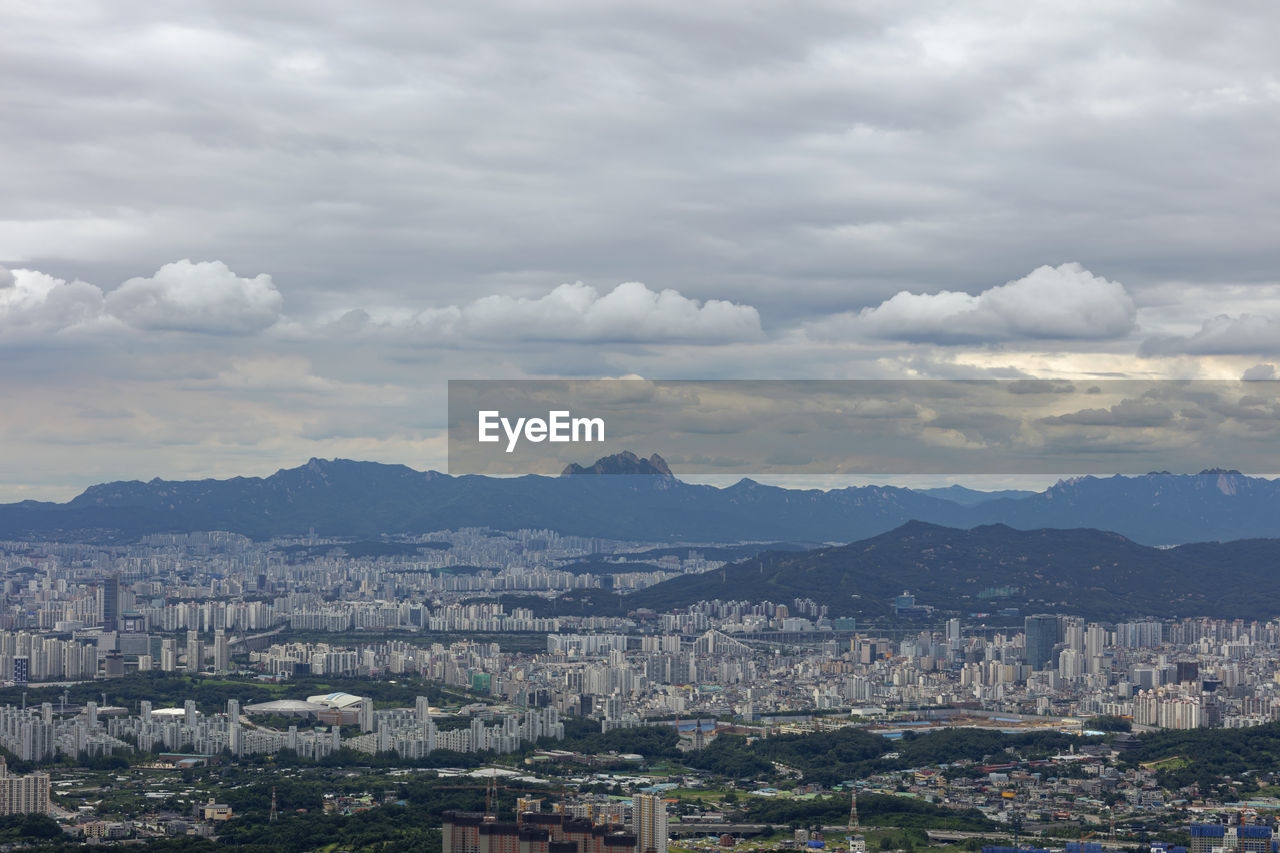 HIGH ANGLE VIEW OF ILLUMINATED CITYSCAPE AGAINST SKY