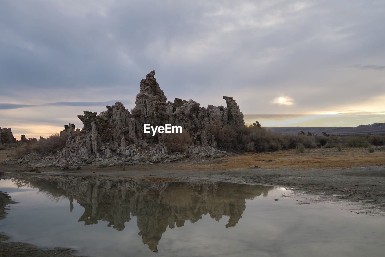 Reflection of rocks in water at sunset