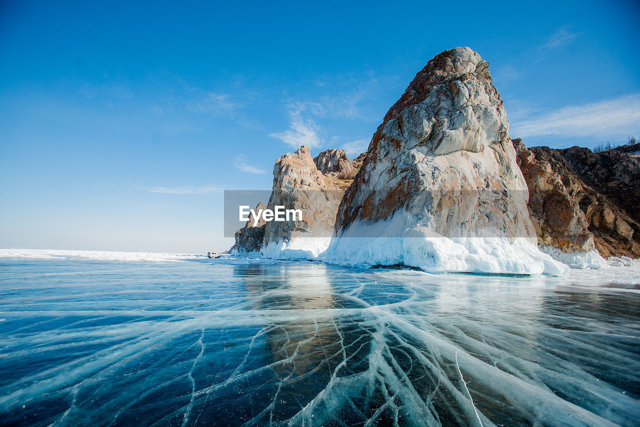 Scenic view of frozen lake against blue sky