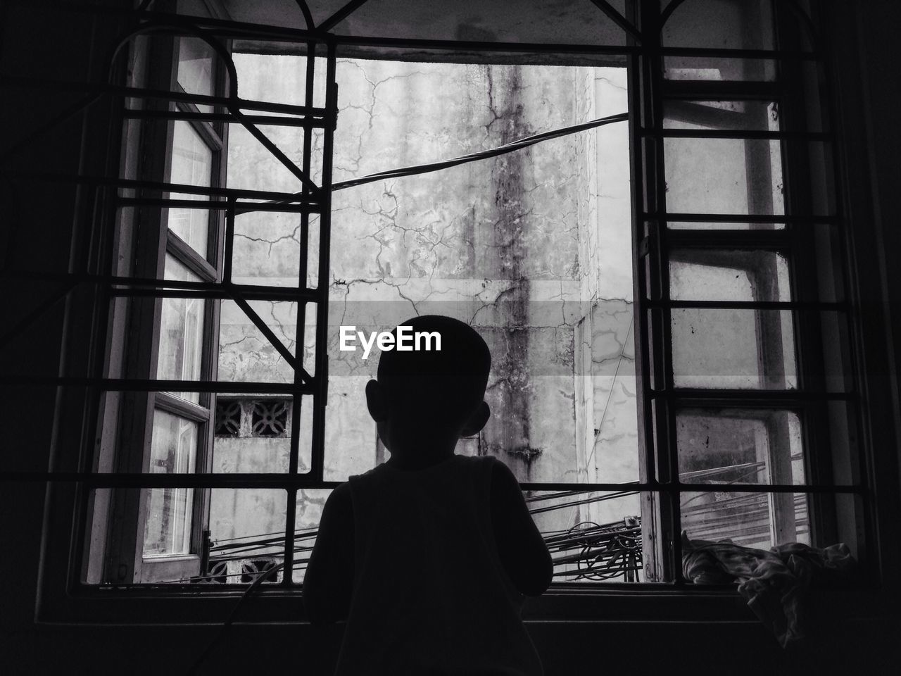 Boy looking through window at home