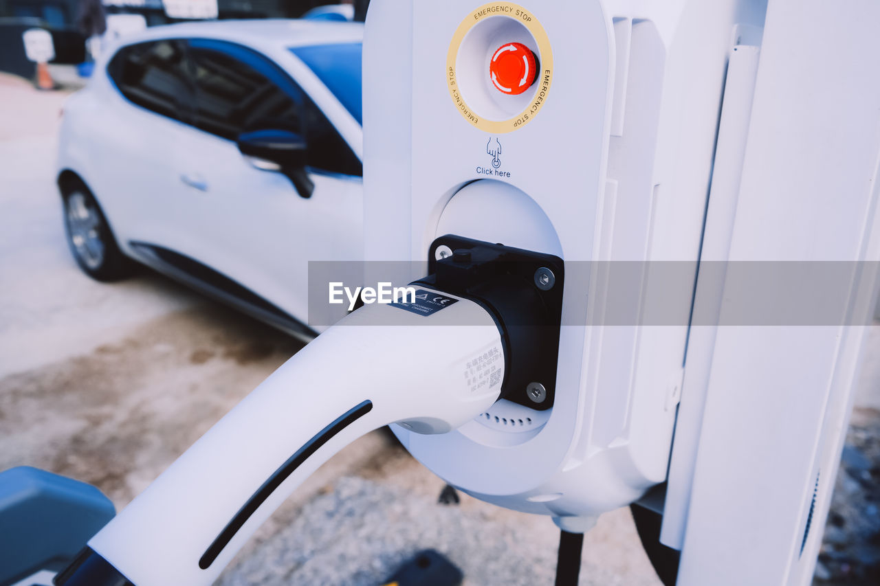 White charging station for electric car with the power cable.  eco-friendly sustainable energy