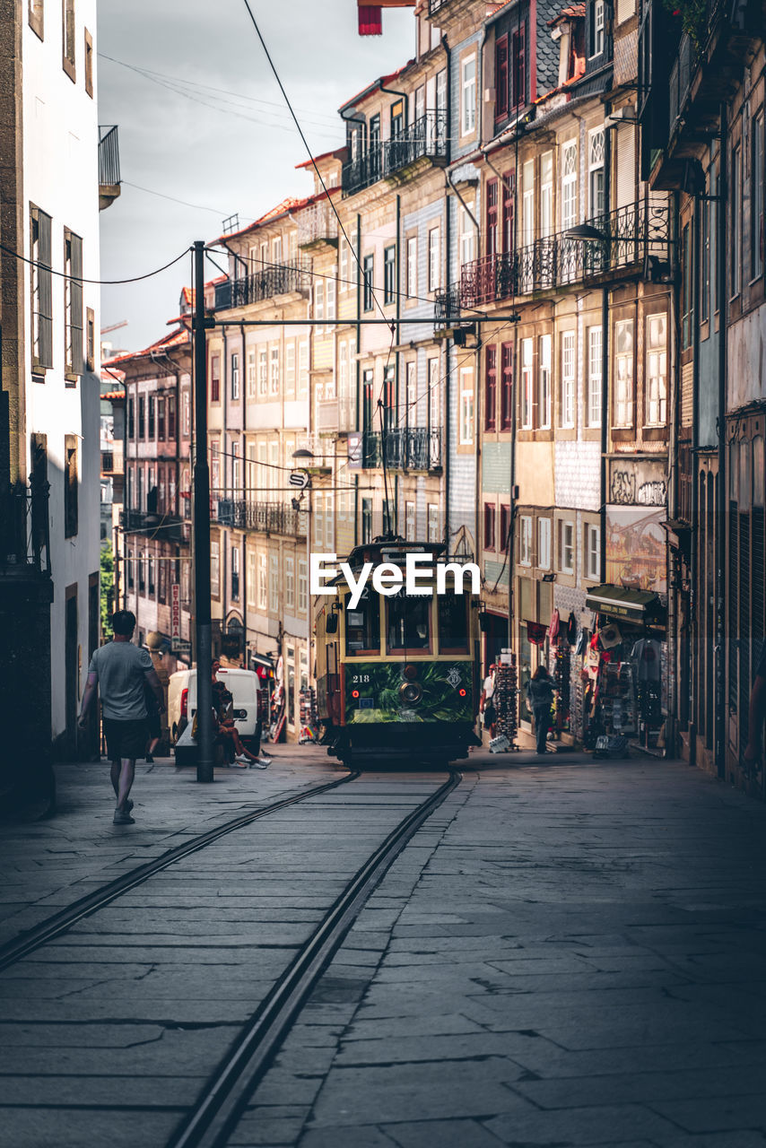 People walking on street amidst buildings in city