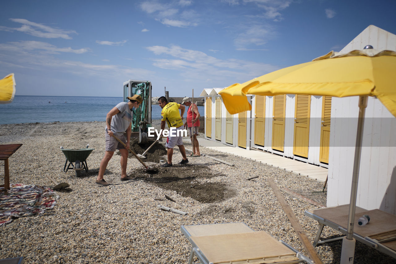 PEOPLE ON BEACH AGAINST SKY