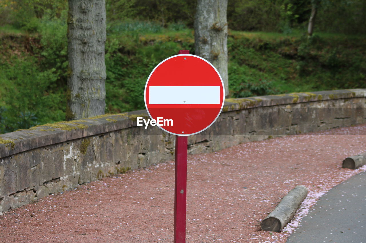 Red road sign on sidewalk