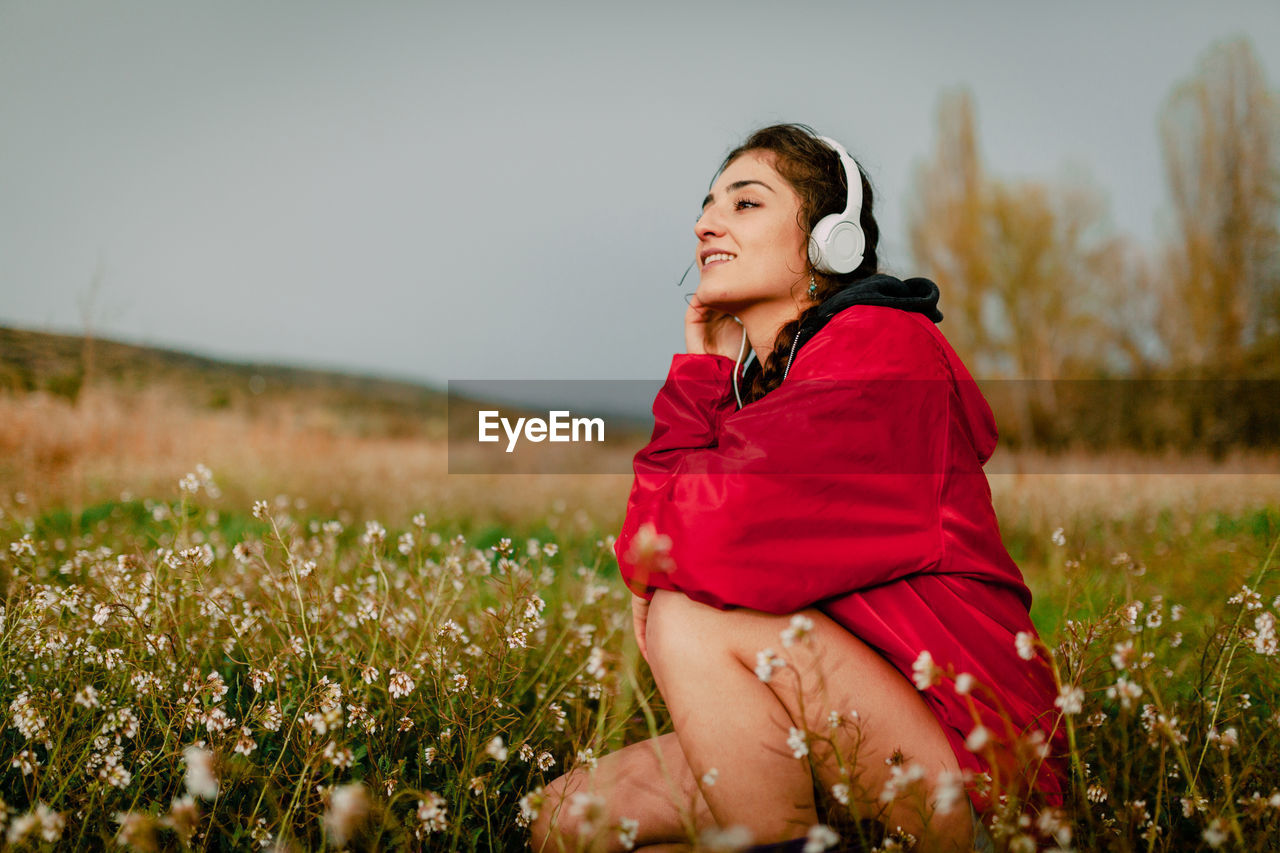 Side view of smiling woman on field