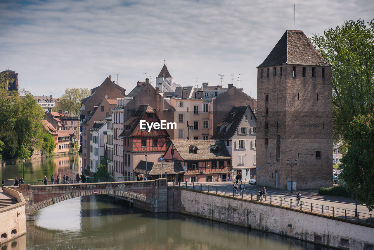 Bridge over river against buildings in city