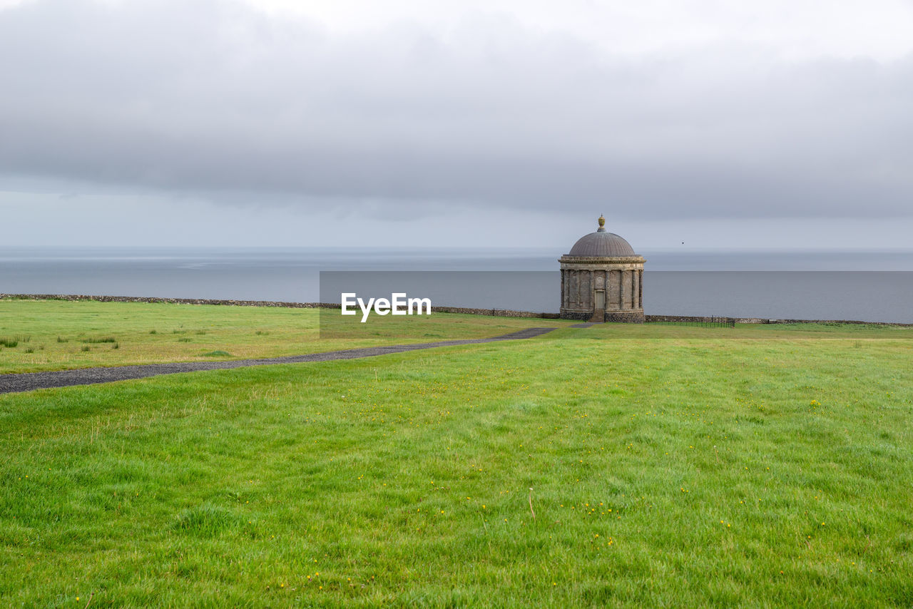 BUILT STRUCTURE ON FIELD AGAINST SKY