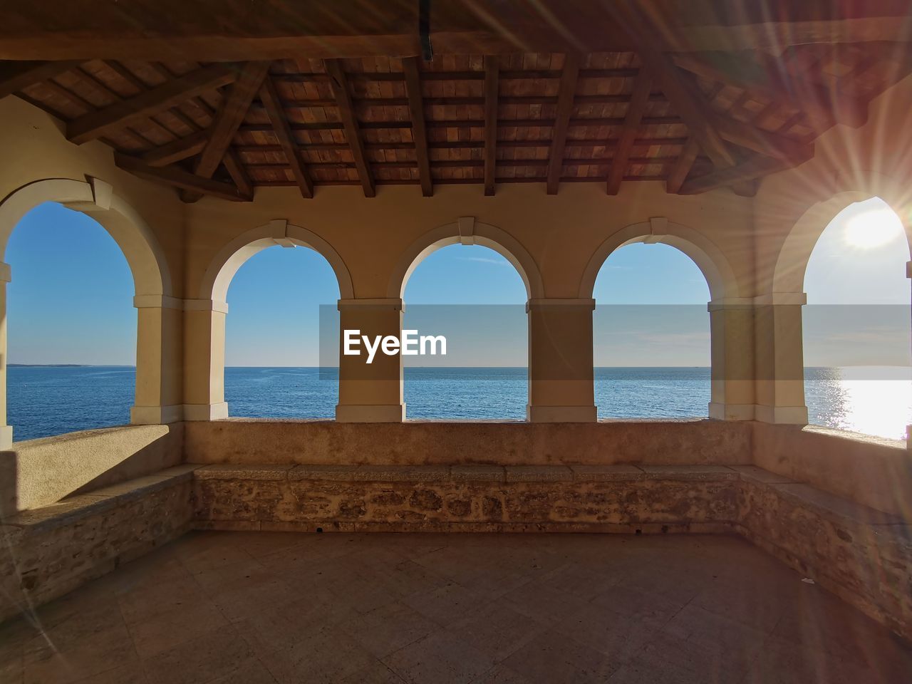 sea, water, arch, architecture, sky, horizon over water, nature, travel destinations, horizon, built structure, travel, beach, land, estate, no people, beauty in nature, scenics - nature, sunlight, tourism, outdoors, day, tranquility, history, clear sky, vacation, trip, blue, the past, tranquil scene