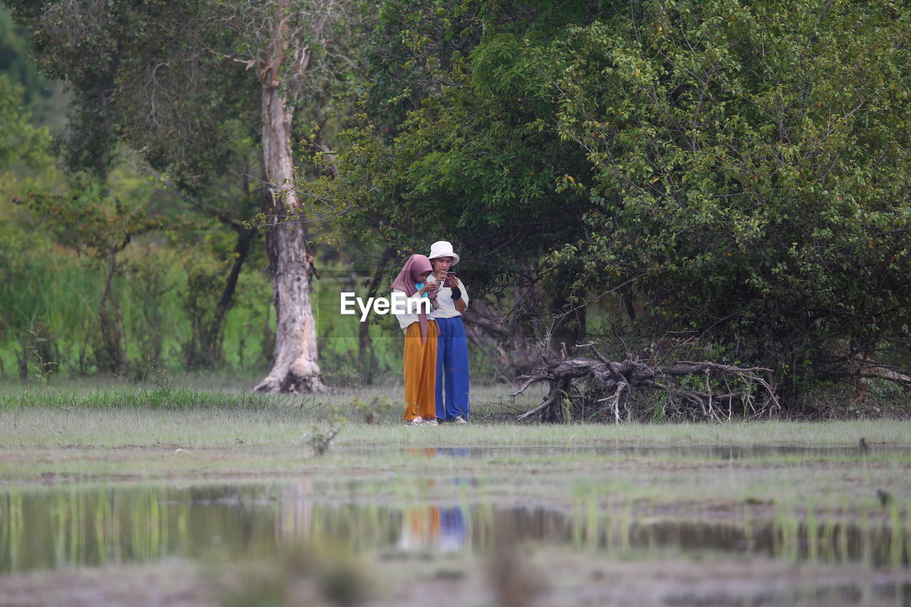 Rear view of woman standing in lake