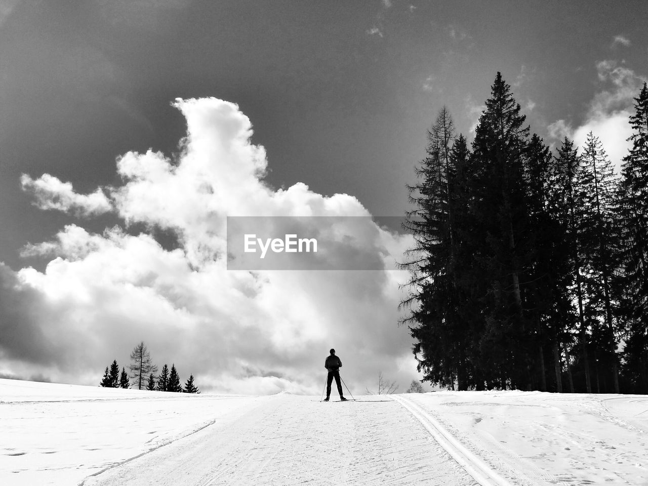 Silhouette man on snow covered field against sky
