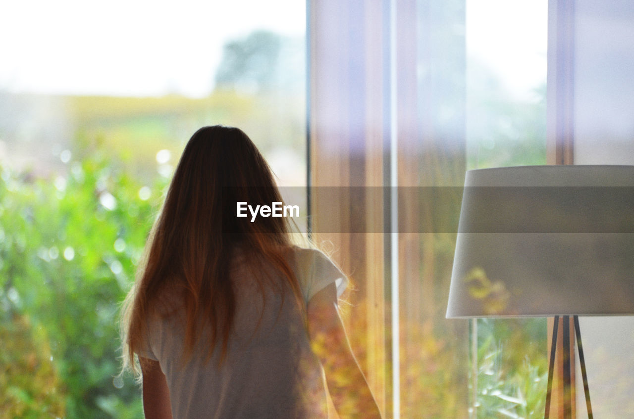 Rear view of woman in glass window