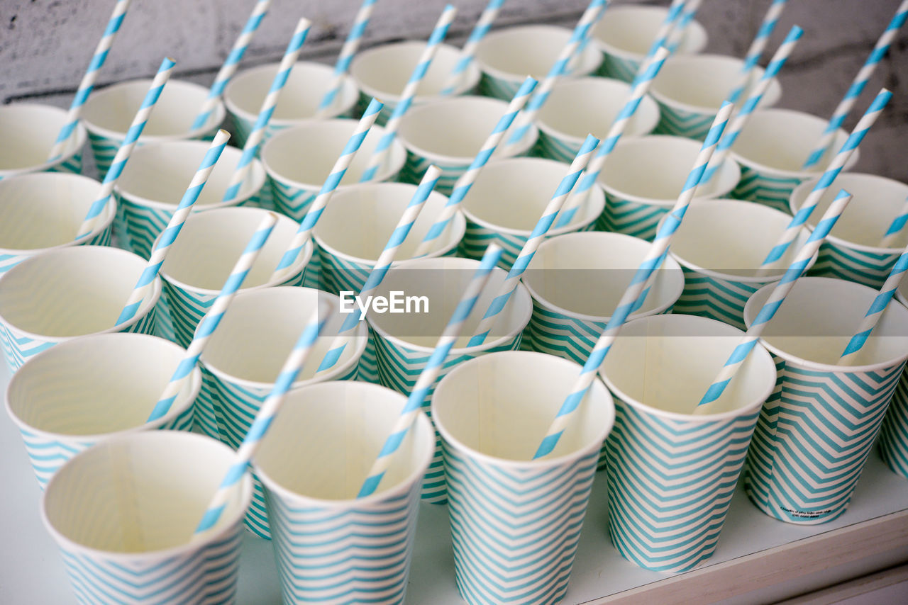 Close-up of disposable cups with striped drinking straws