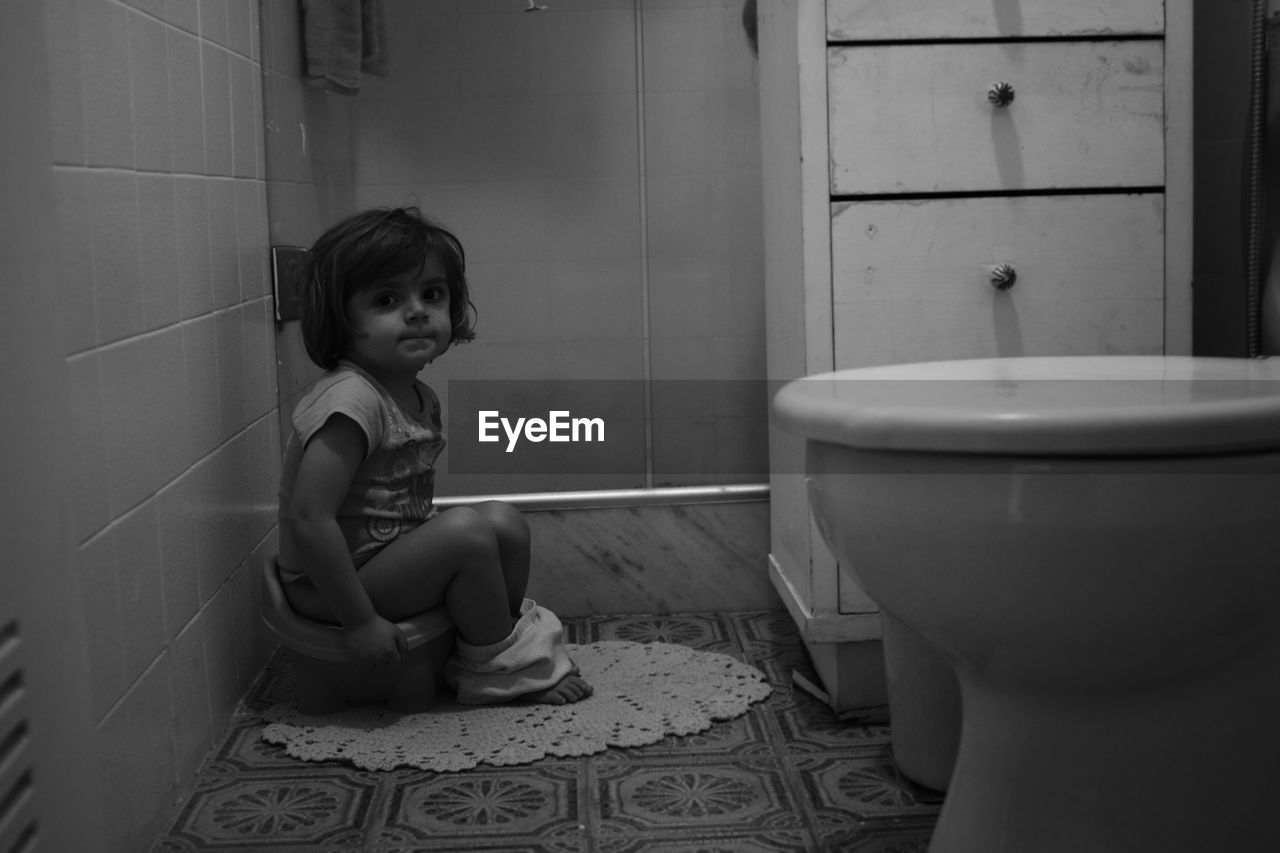 Portrait of girl sitting in bathroom