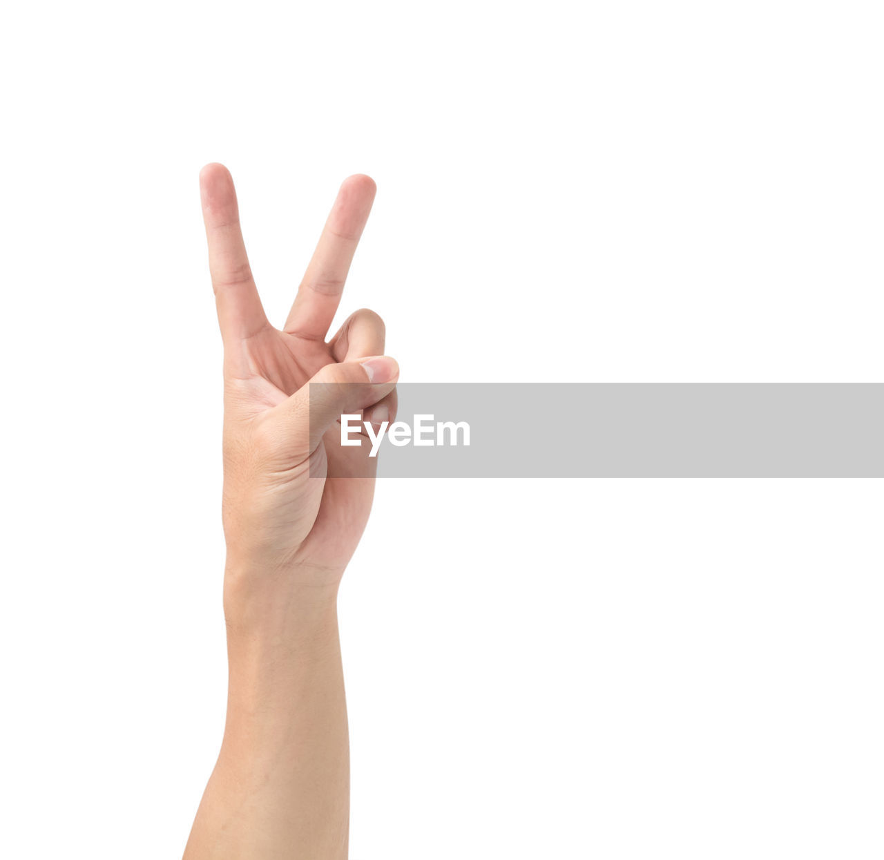 Cropped image of hand gesturing peace sign over white background