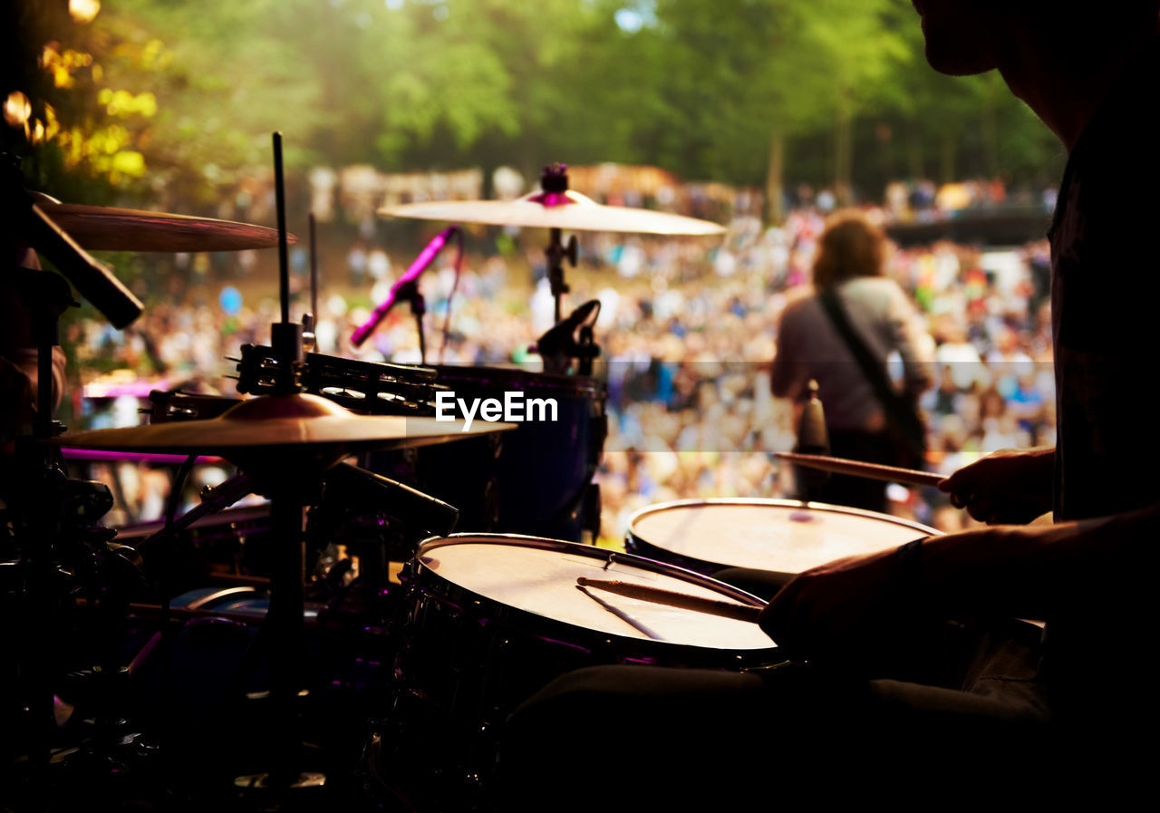 Midsection of man playing drum