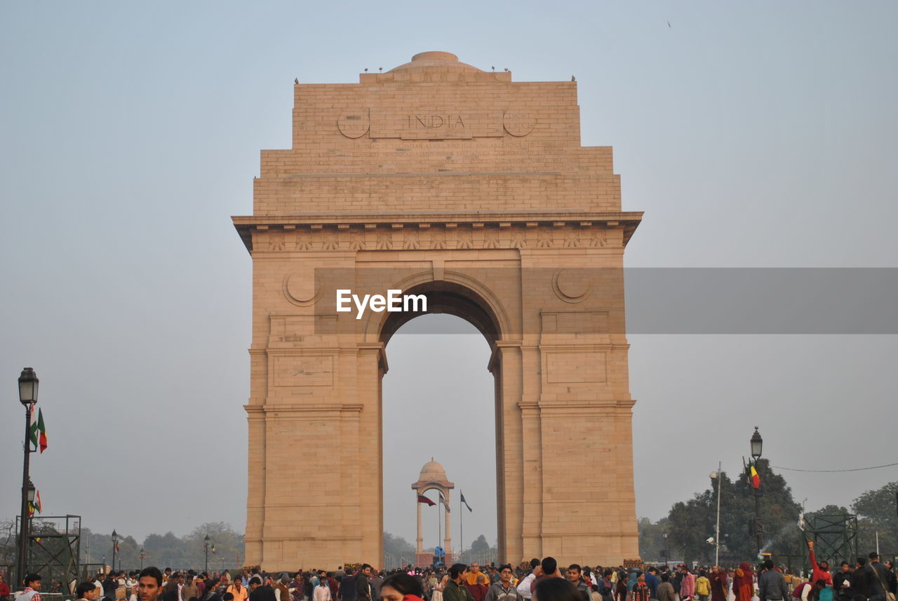 Tourists visiting india gate against clear sky