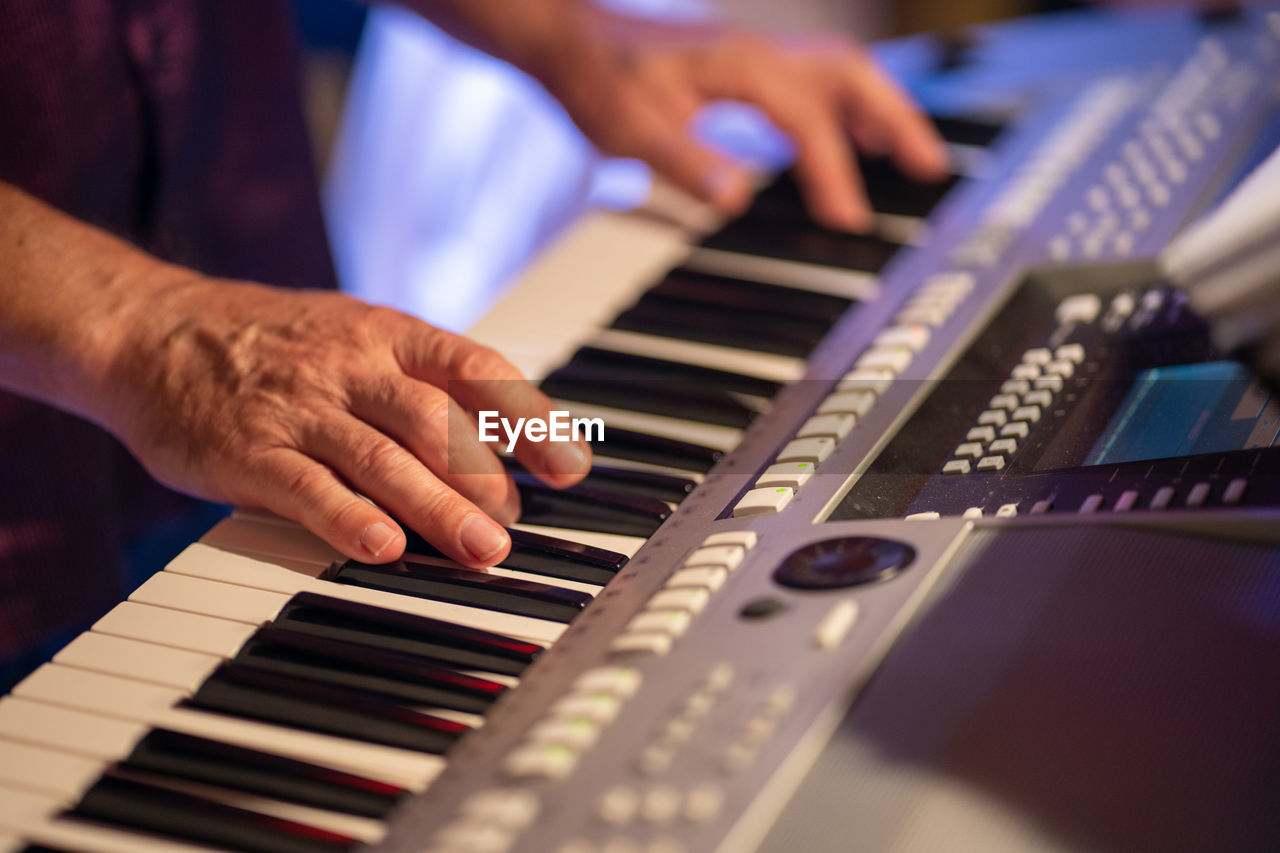 Midsection of man playing piano