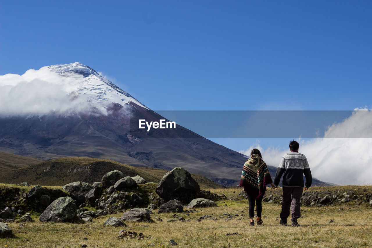 Rear view of people on snowcapped mountains against sky