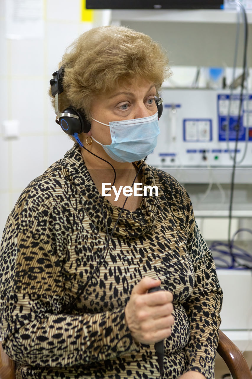 Audiologist checks the hearing of an older woman