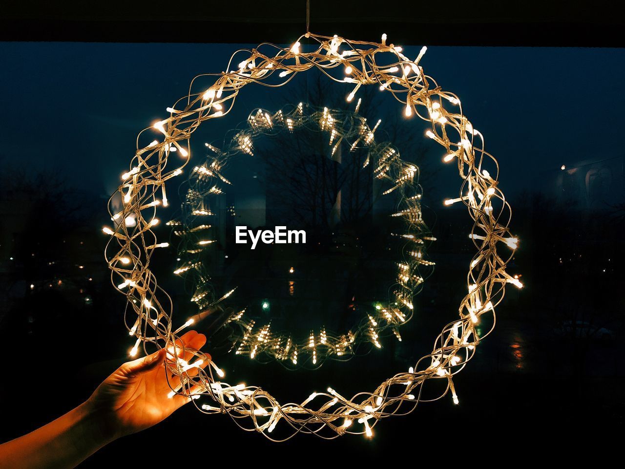 Cropped hand holding illuminated string light