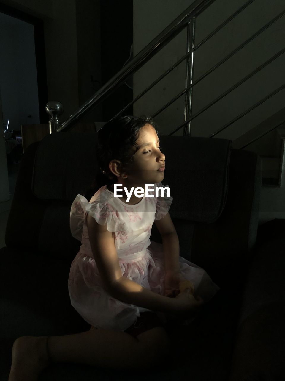 BOY SITTING ON SOFA AT HOME