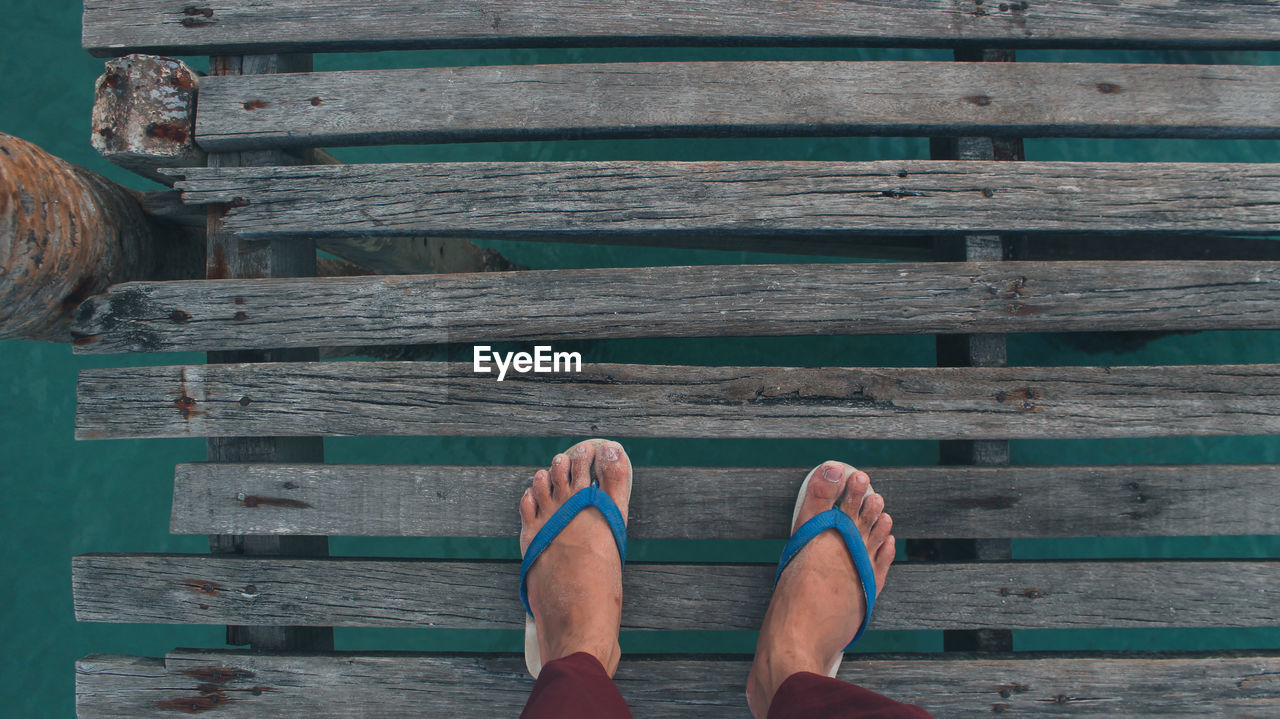 LOW SECTION OF PERSON STANDING ON PIER