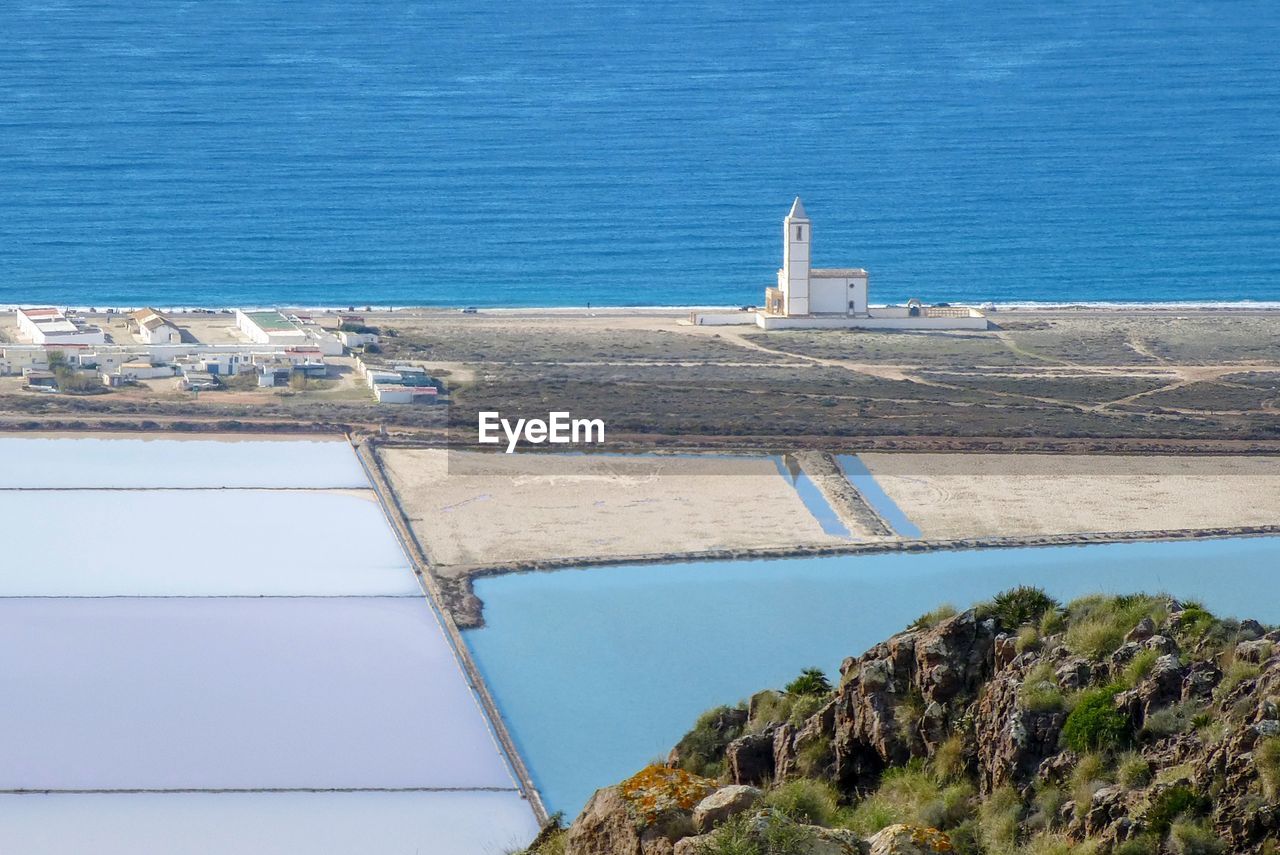 High angle view of sea and las salinas de cabo de gata church against sky