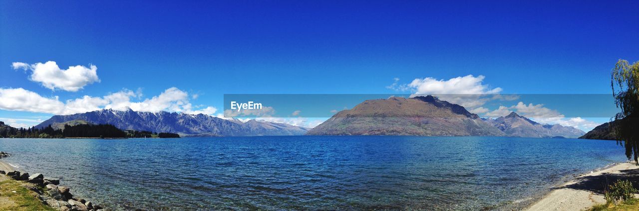 Panoramic view of lake by mountains against sky