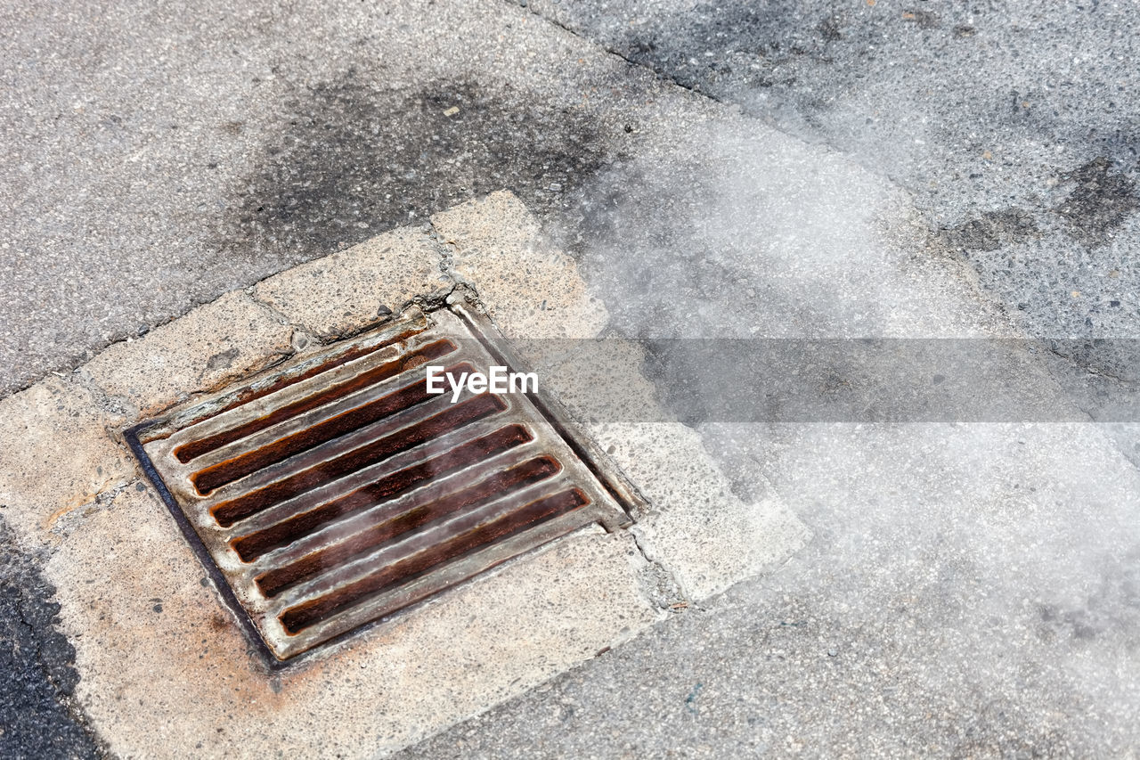 HIGH ANGLE VIEW OF MANHOLE ON STREET