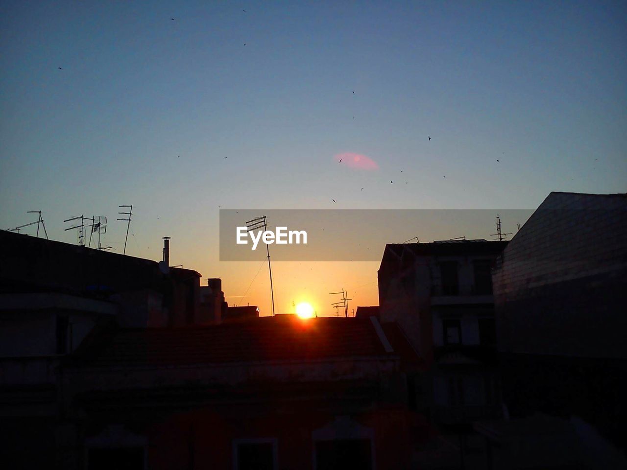 LOW ANGLE VIEW OF BUILDINGS AT SUNSET