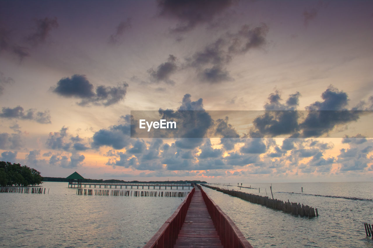 Pier over sea against sky during sunset