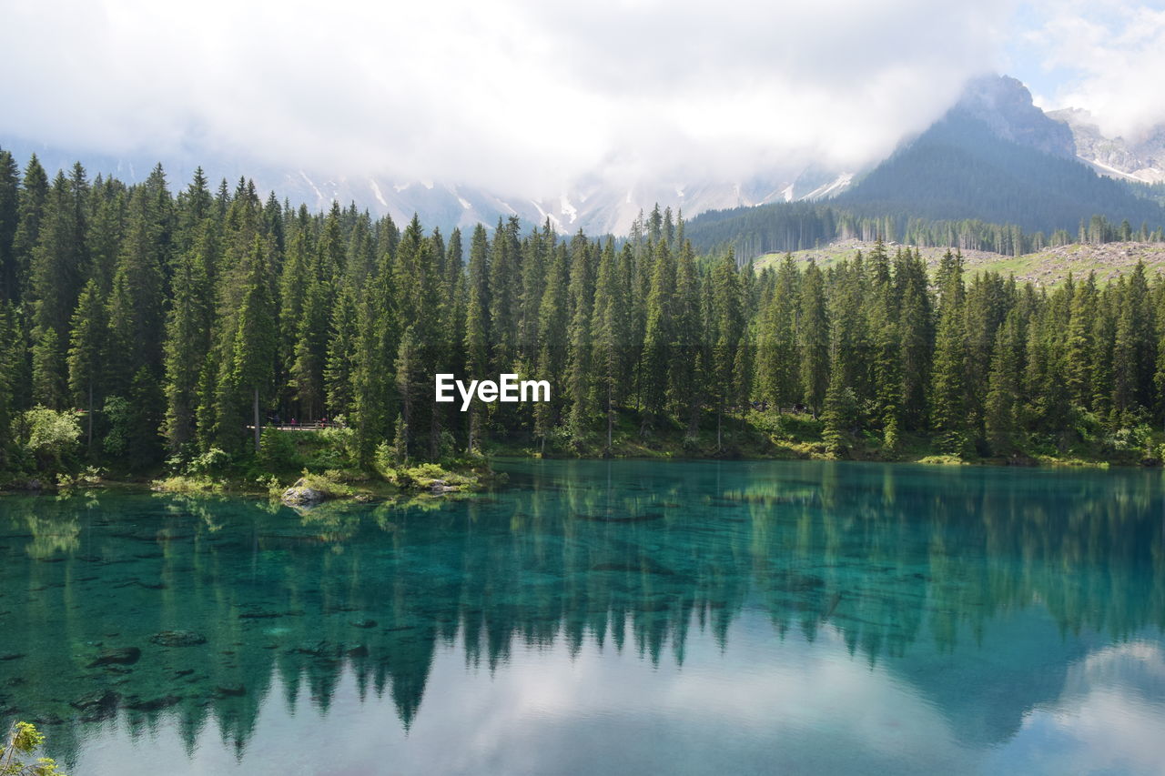 Scenic view of lake by mountains against sky