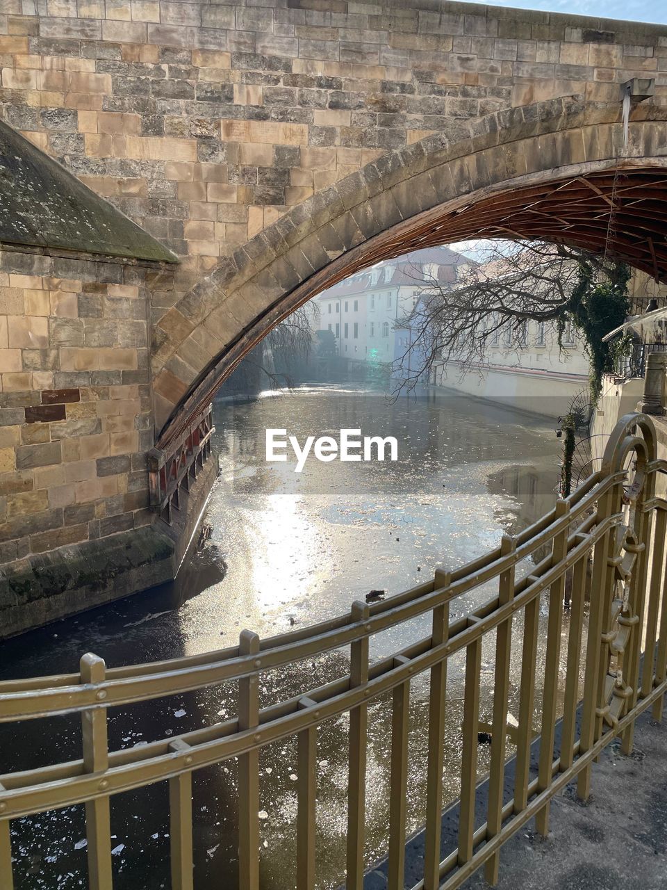 bridge over river amidst buildings in city