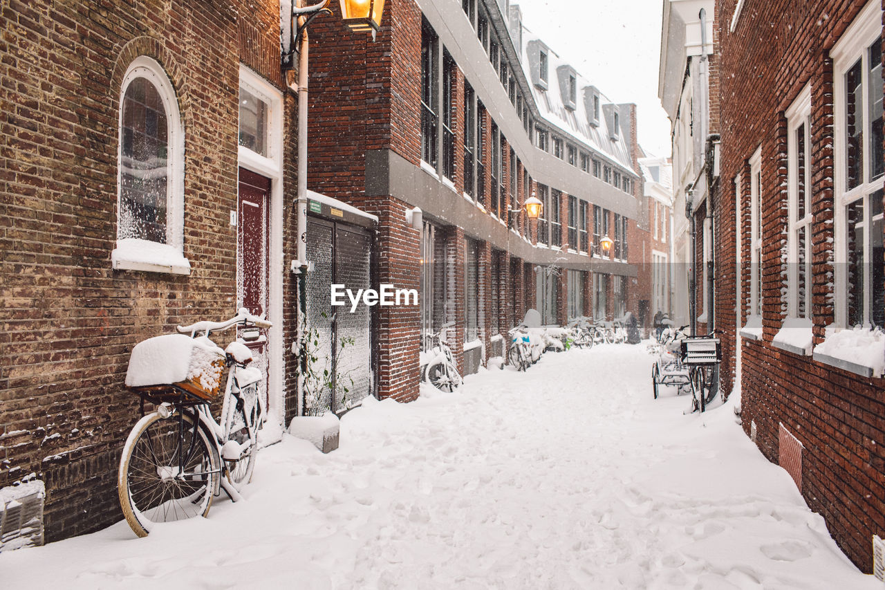 Street amidst buildings in city during winter