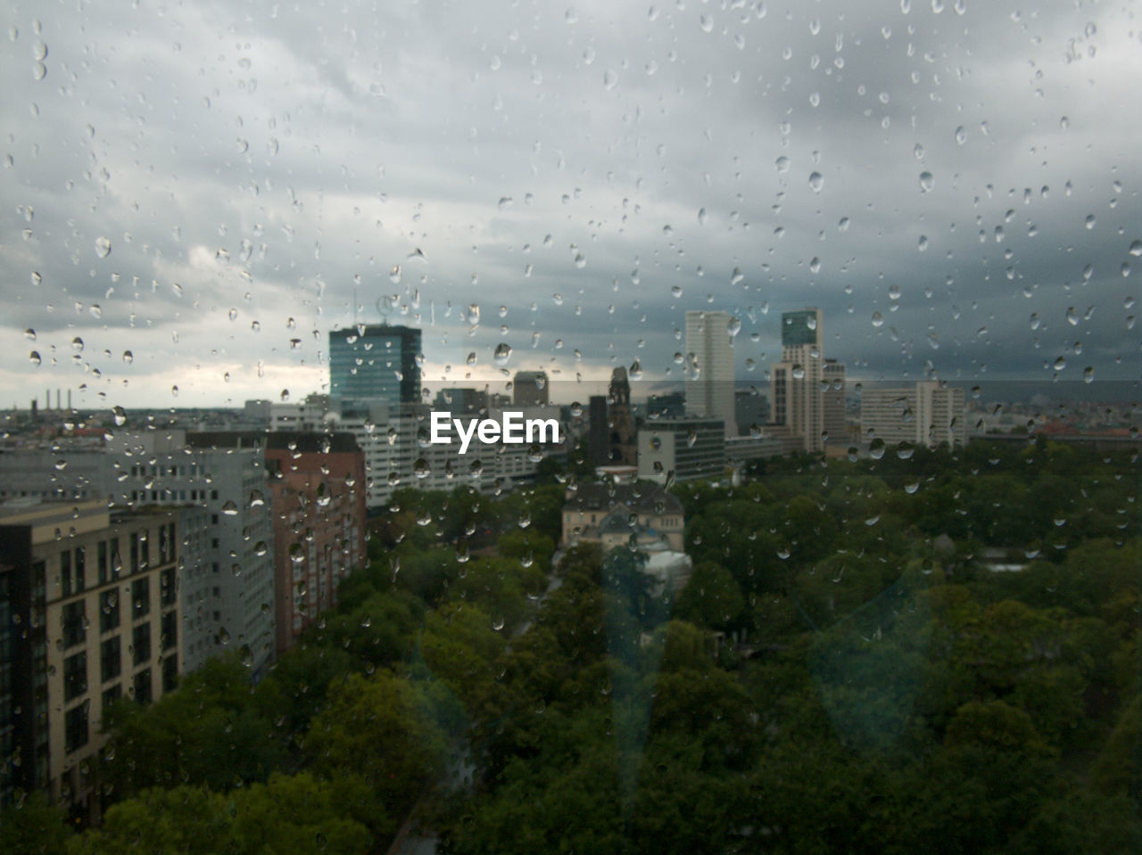 CITY BUILDINGS SEEN THROUGH WET WINDOW