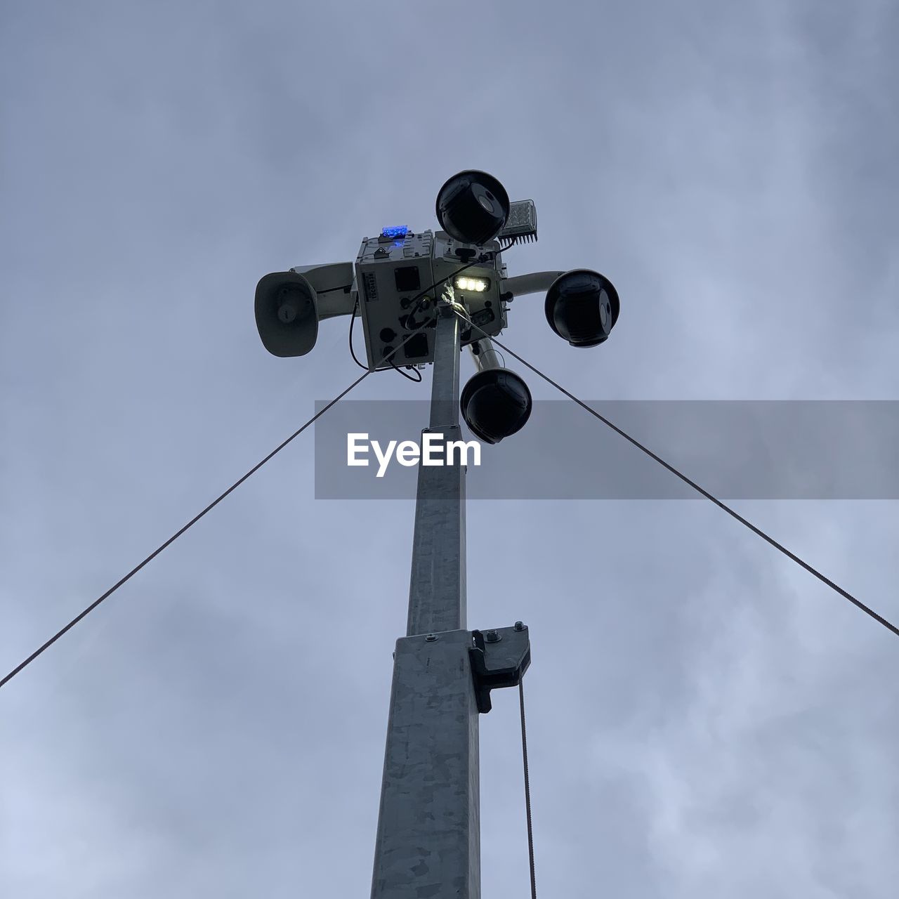 technology, sky, low angle view, cloud, communication, security camera, no people, surveillance, light fixture, nature, mast, street light, wind, lighting, blue, day, outdoors, lighting equipment, machine, cable, architecture, broadcasting