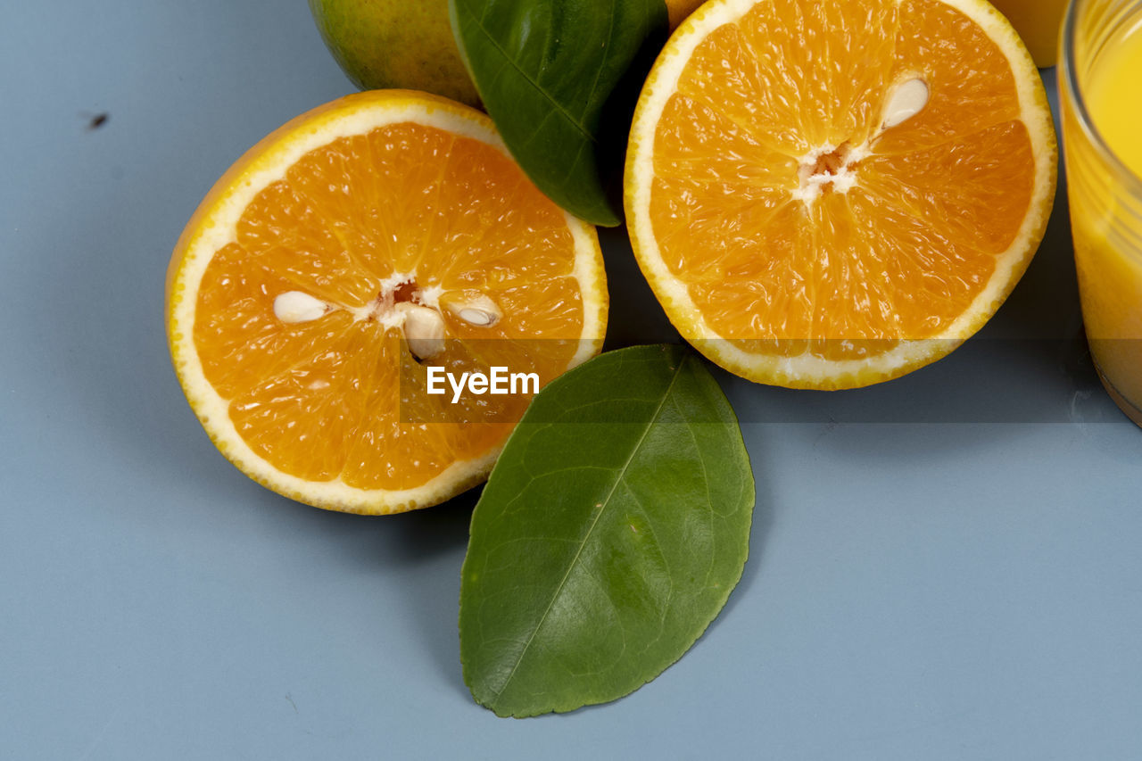 Natural orange juice in the glass with bottle on the side close up