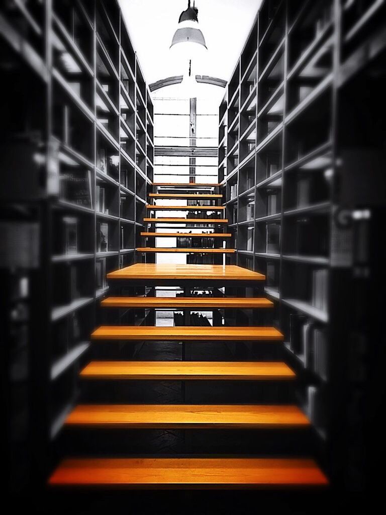 Staircase amidst shelves in library