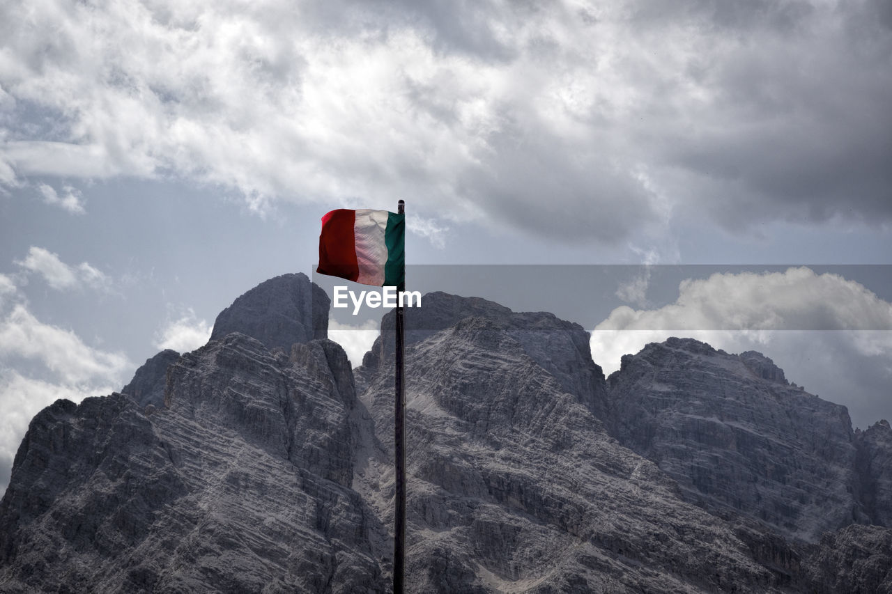 LOW ANGLE VIEW OF FLAG AGAINST MOUNTAINS