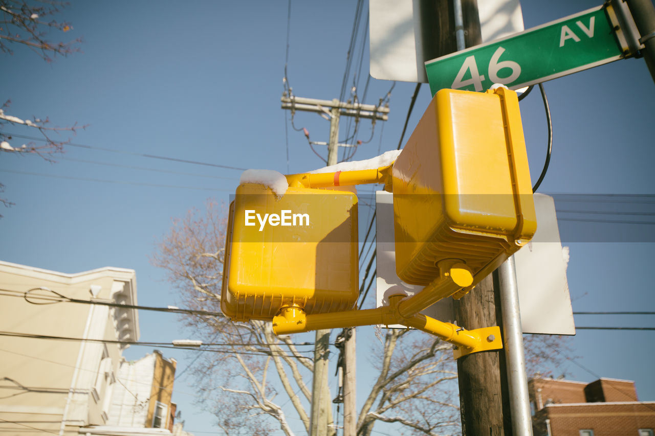 Low angle view of yellow road signal against sky