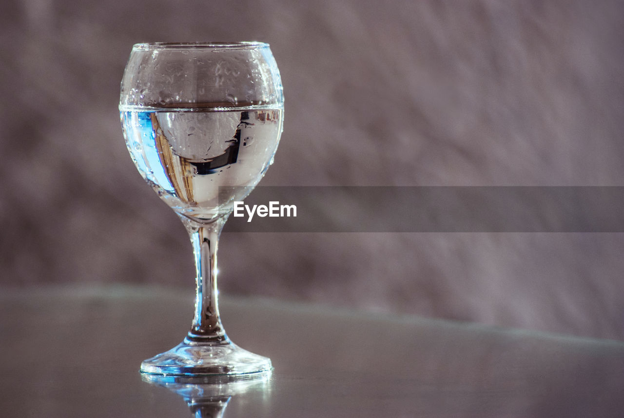 CLOSE-UP OF GLASS OF WINE ON TABLE