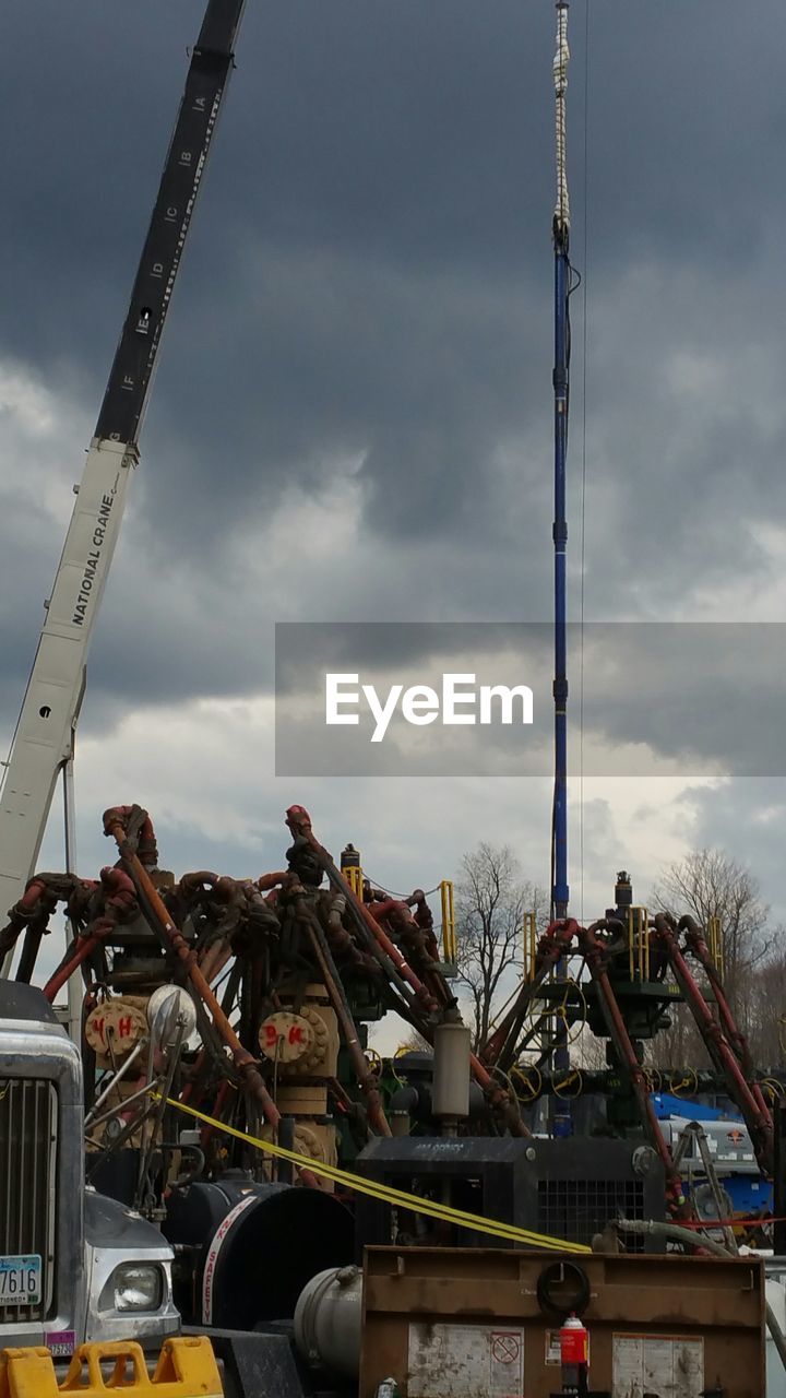 LOW ANGLE VIEW OF CONSTRUCTION SITE AGAINST CLOUDY SKY