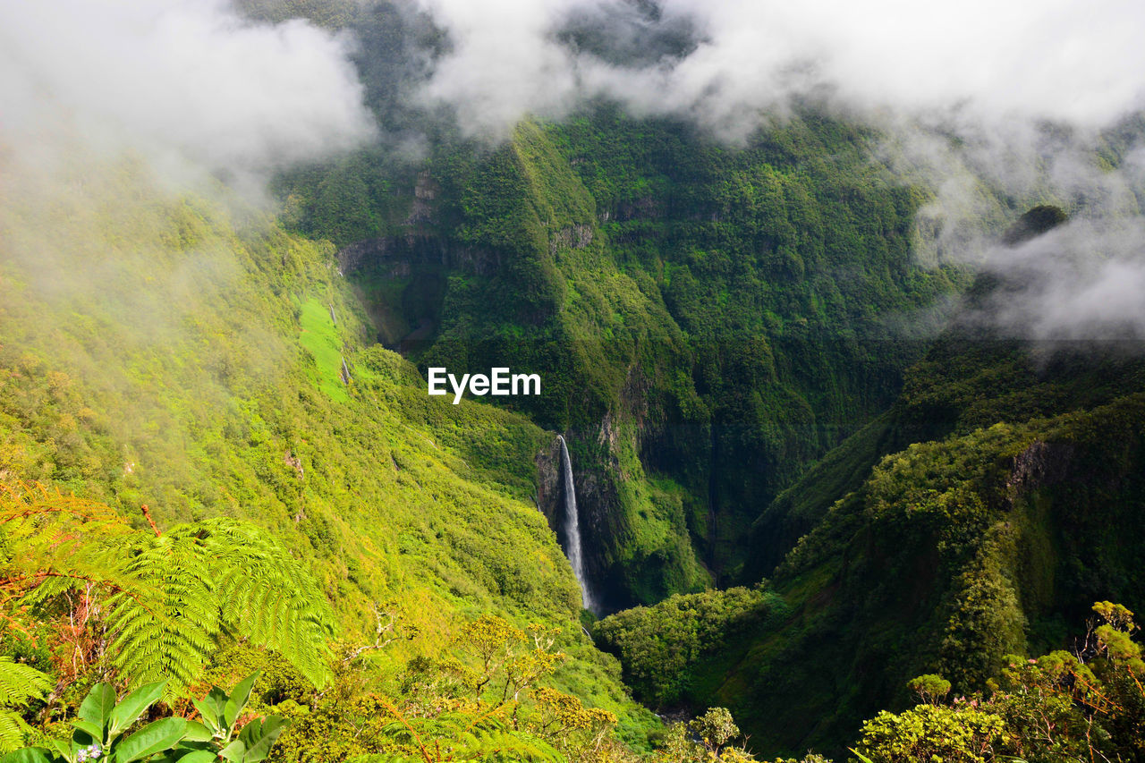 High angle view of clouds over grassy mountains