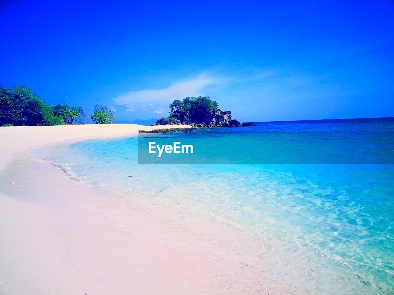 Scenic view of beach against blue sky