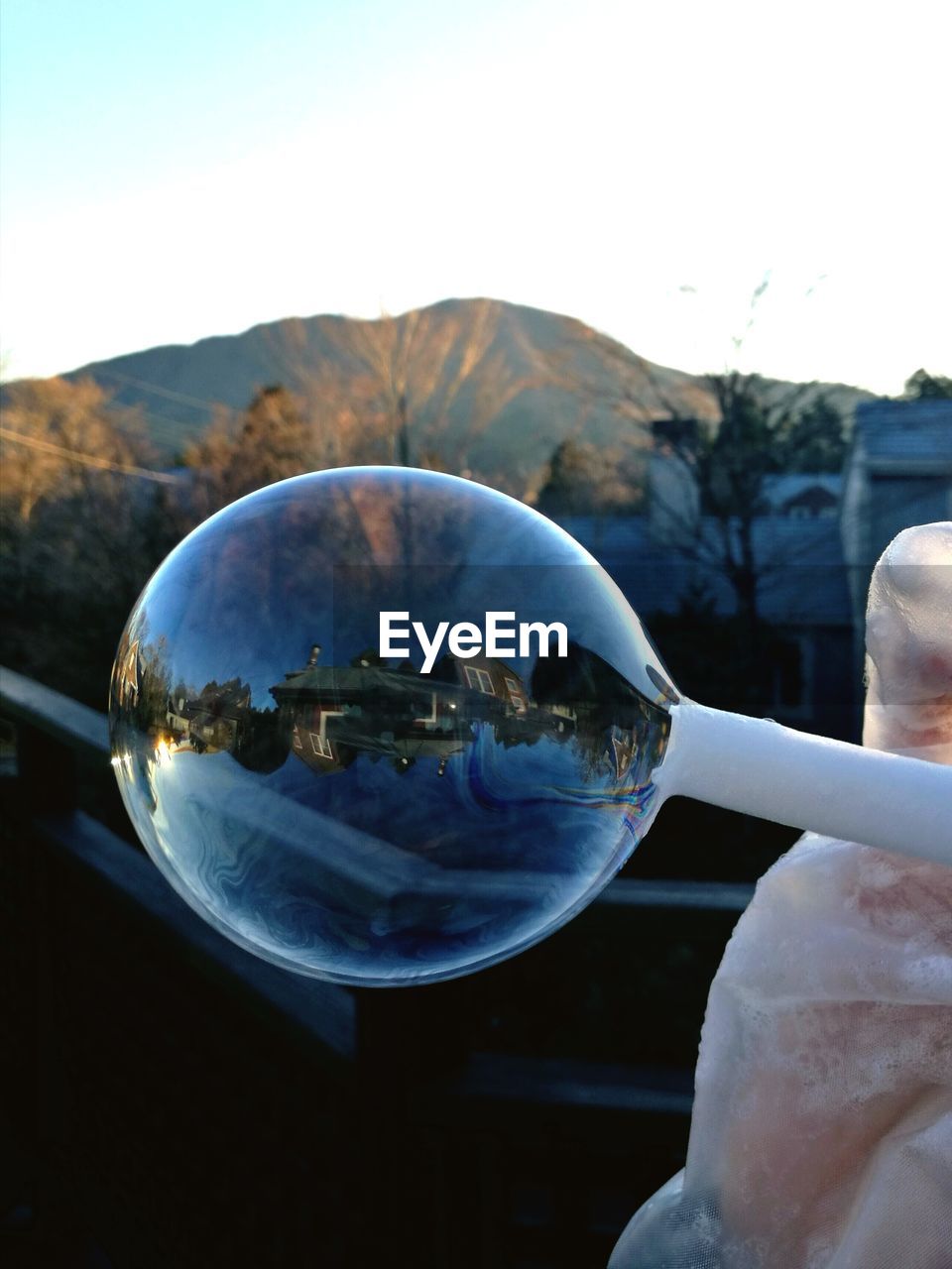 CLOSE-UP OF HAND HOLDING BUBBLES IN WATER