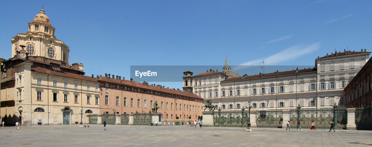 View of buildings in town against blue sky