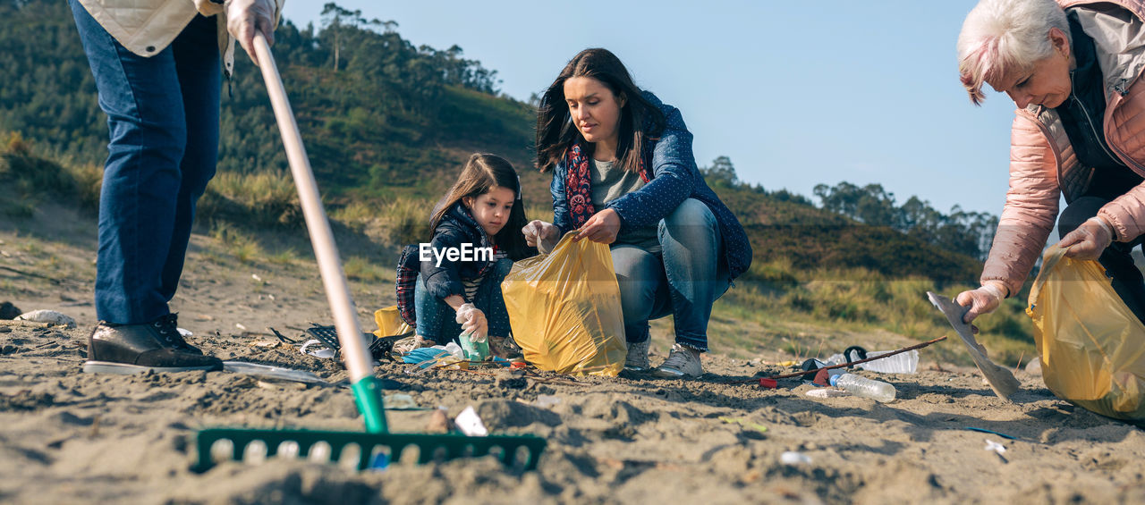 Family picking garbage at beach